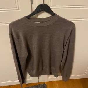 Brun/beige stickad tröja från Sandö - Säljer en enkel och stilren beige stickad tröja från Sandö. Tröjan är ganska varm men fortfarande tunn och passar perfekt till sommaren då den är lätt att bära runt på men även snygg att ha på sig. Säljer då den är för liten för mig. Nypris 800 och är i ett ny skick då den knappt är använd