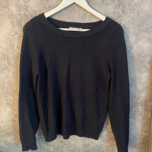 Mörkblå stickad tröja från Vila - En enkel och stilren mörkblå stickad tröja från Vila. Tröjan har rund halsringning, långa ärmar och ribbade muddar vid ärmslut och nederkant. Perfekt basplagg för garderoben. Använts fåtal gånger 