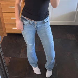 Ljusblå bootcut jeans från True Religion - Säljer ett par ljusblå jeans från True Religion i modellen Becca med bootcut. Jeansen har klassiska broderade bakfickor och mellanblå tvätt. Midjan är midwaist och passformen är normal. Perfekta för dig som gillar en tidlös jeansstil.