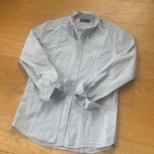 Randig skjorta från Morris  - ❤️Tar emot Bud så va snabb !! ❤️Snygg blåvit randig skjorta från Morris med klassisk krage och knäppning framtill. Skjortan är långärmad och har en stilren, tidlös look. Tillverkad i mjuk bomull som känns skön mot huden. Perfekt för dig som gillar en clean och fräsch stil ny skick perfekt till sommaren bäst pris på marknaden så var snabba ! 