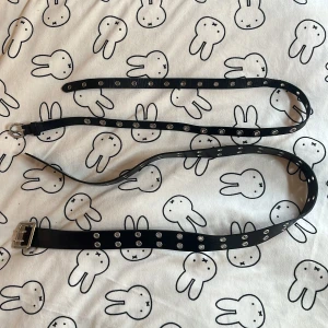 Två svarta bälten med nitar - Två svarta nitbälten. Syntetläder. Det smala bältet är 102 cm och det breda är 110 cm. Säljer bältena ihop. 🩷