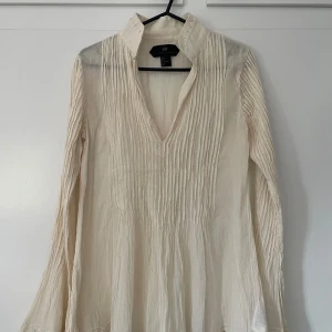 Krämvit blus med trumpetärm - Strukturerad bomullstyg