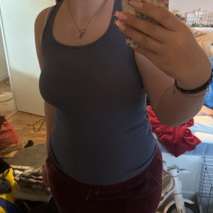 Mörkgrå ribbad linnetopp från Miss Milla - Säljer en mörkgrå ribbad linnetopp från Miss Milla i storlek M. Toppen är ärmlös med rund halsringning och har en tight passform. Perfekt för sommaren och enkel att matcha med olika outfits.