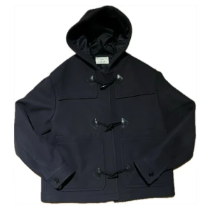 Duffeljacka  - Säljer en snygg svart duffeljacka från Zara med huva och klassiska knäppningar. Jackan har en stilren design med stora fickor framtill och är perfekt för våren. Den är tillverkad i ett mjukt material som ger en bekväm passform. Storlek L passar mig perfekt på 185cm som brukar ha L-M.