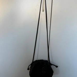 Svart flätad axelväska - Säljer denna slutsålda supersnygga bow19 handväskan🙌🏼🙌🏼Är helt oöppnad, se sida 5💕Säljer då jag har dubbletter. Kan tänka mig att gå ner i pris vid snabb affär.