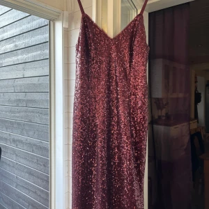 Vinröd balklänning Glittrig - Glittrig med paljetter, balklänning som inte passade. Har en slits vid benet och är i väldigt fint skick