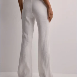 Vita linnebyxor - Snygga vita linnebyxor med låg midja och en avslappnad passform. Byxorna har en rak och vid stil som ger en elegant look. Perfekta för varma dagar och kan enkelt matchas med olika toppar. Bilderna lånade från hemsidan. Knappt använda pga passar inte min kroppstyp.