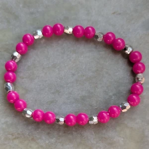 Rosa och silverfärgat pärlarmband - Snyggt armband med rosa och silverfärgade pärlor. Perfekt för att lägga till en färgklick till din outfit. Elastiskt band för enkel passform.