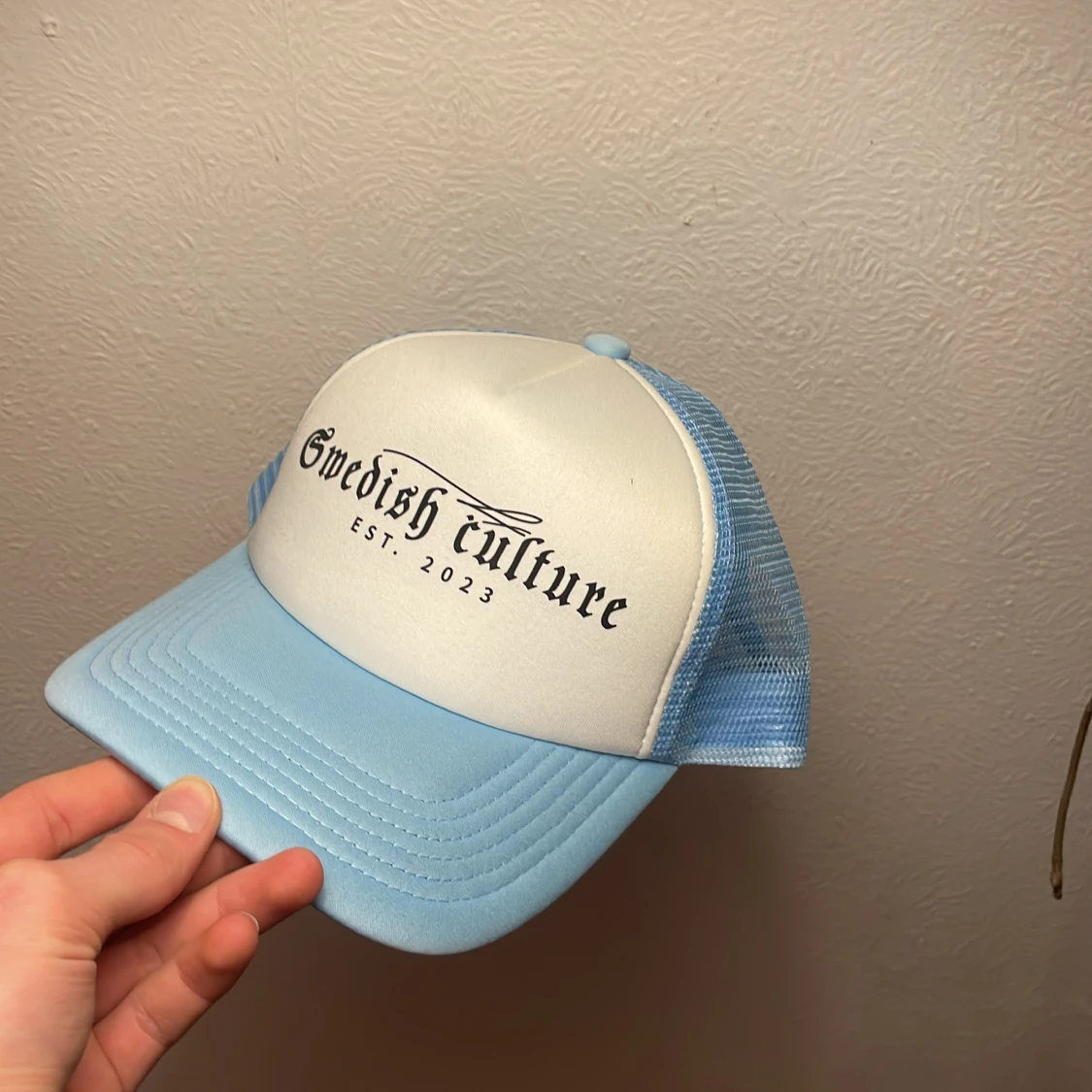 Ljusblå och vit keps med text - 1
