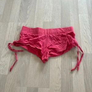 Rosa shorts från e-vie - Säljer ett par rosa shorts från e-vie. De har en bekväm passform med knytband i sidorna för justering. Perfekta för varma sommardagar!