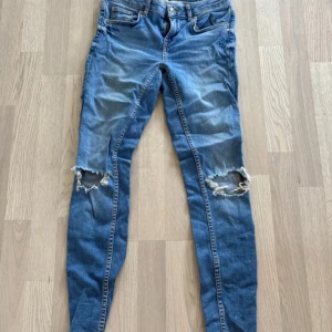 Blå jeans med slitna knän - Snygga blå jeans från Perfect Jeans med slitna detaljer vid knäna. De har en klassisk femficksdesign och en bekväm passform. Perfekta för en avslappnad stil.