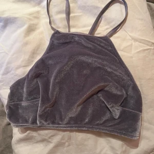 Lila sammetstopp med spetsdetaljer - Säljer en snygg lila sammetstopp med smala axelband och spetsdetaljer på baksidan. 