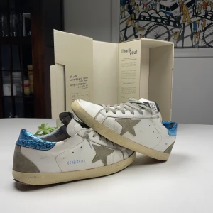 Golden Goose Super-Star  - Säljer nu mitt par fina Golden Goose som jag ägd i 3 månader men börjar nu bli lite för små. Skorna är i bra skick. De har slitage på hälen och sulan har drag. Skorna är super sköna och funkar perfekt för sommaren som närmar sig! Skorna är äkta och detta visa bland annat på lådan! PM vi frågor eller mer bilder! 🍾🌴