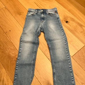 Blå jeans från Replay - Snygga blå jeans från Replay med en klassisk femficksdesign och knappgylf. De har en lätt tvättad look och är perfekta för en avslappnad stil. Märkeslappen sitter på baksidan av midjan.