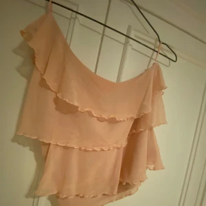 Rosa volangtopp från Cubus - Säljer en söt rosa volangtopp med flera lager volanger. Perfekt för varma dagar. Den har en luftig och lätt design som ger en romantisk känsla. (den är ganska liten för sin storlek)