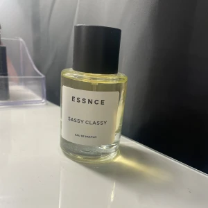 Essnce Sassy Classy Eau de Parfum - Säljer en elegant flaska av Essnce Sassy Classy Eau de Parfum. Flaskan är genomskinlig med en stilren svart kork och en enkel etikett. Perfekt för den som vill ha en sofistikerad och självsäker doft. Har bara använt en gång för att prova. Den är verkligen så lik YSL libre men tyvärr faller inte doften mig i smaken och därför säljer jag den.