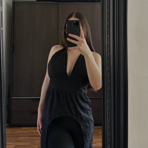 Svart klänning från Bik Bok - Snygg svart klänning från Bik Bok med broderade detaljer. Klänningen har en djup v-ringning och knytband i nacken. Perfekt för en elegant look.🥰🥰🥰