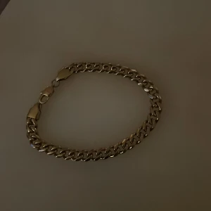 Guldarmband med kedjedesign - Snyggt guldarmband med en klassisk kedjedesign. Perfekt för att ge en elegant touch till din stil. Armbandet har en säker låsning och en glansig finish.