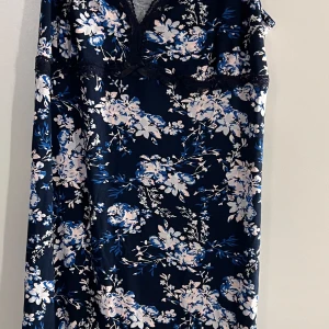 Blommig sov linne från Esmara - Säljer en vacker blommig klänning från Esmara i mörkblått med vita och rosa blommor. Klänningen har en v-ringad design och är tillverkad i mjuk viskos med lite stretch. Perfekt för en somrig look!