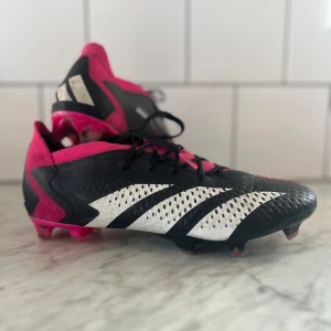 Adidas Predator Accuracy.1 FG - Säljer mina Adidas Predator Accuracy.1 FG, i bra skick! Använda ett fåtal gånger och kommer i originalkartong. Perfekta fotbollsskor för dig som vill ha max kontroll och precision på planen. 	•	Svart/vit/rosa färg 	•	För fasta underlag (FG) 	•	Grymt grepp och bra känsla tack vare High Definition Grip 	•	Skön och stabil passform med snörning. Det är storlek 40 2/3.   Nypris ca 2300 , säljer för 700 kr.  Köparen står för frakt! Hör av dig vid frågor!