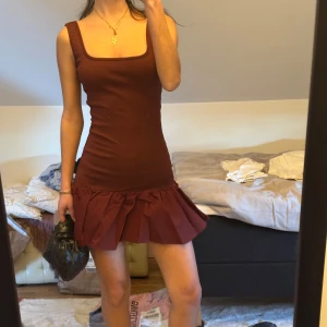 Vinröd klänning med volangdetalj - Snygg vinröd klänning med volangdetalj vid fållen Aldrig använd, lappar kvar , nypris 400kr.