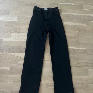 Svarta jeansbyxor från Lindex - Snygga svarta baggy jeansbyxor från Lindex med hög midja. Byxorna har en knapp och dragkedja framtill och är perfekta för en stilren look. Passar bra till både vardag och mer uppklädda tillfällen.