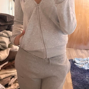 Mjukis set - Säljer en bekväm och stilren grå hoodie med dragkedja. Perfekt för en avslappnad look. Den har långa ärmar och en praktisk ficka framtill. Passar bra till vardags eller för en mysig hemmakväll. Matchade byxor följer med, de är långa. Kan sälja separat.
