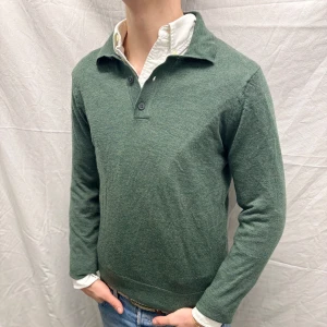 Grön merinoullströja från Riley - Säljer en stilren grön tröja från Riley i mjuk merinoull. Tröjan har en klassisk krage med knappar och långa ärmar. Perfekt för en elegant och bekväm look. Plagget sitter normalt för sin storlek och är i bra skick. Modell på bild är 182 cm/ 68kg. Hör gärna av dig vid fler frågor. Mvh, CAVI