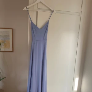 Blå balklänning från Nelly - Säljer denna blå balklänning från Nelly. Klänningen har smala axelband och en v-ringad design. Aldrig använd då jag köpte en annan. Nyskick med lappen kvar. Ursprungspris: 1 199