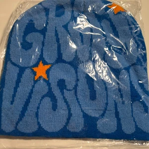 Blå gravity visions mössa - Blå stickad mössa ifrån gravity visions den står gravity visions på framsidan med blått på baksidan är det en blå spindelnät