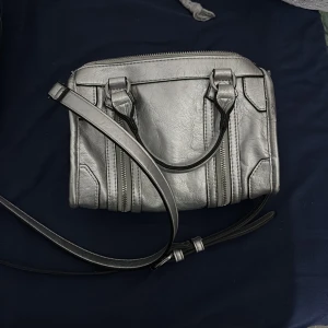 Silvrig axelväska  - Snygg silvrig axelväska med coola detaljer 