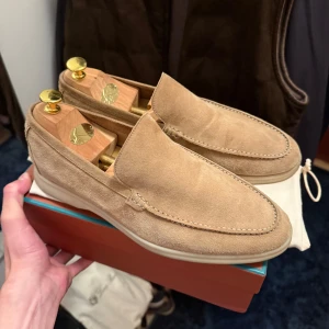 Loro Piana summer walk  - Säljer ett par Loro Piana Summer Walk loafers i beige mocka. Skorna har en stilren och klassisk design med rund tå och platt sula. Insidan är skinnklädd och yttermaterialet är mjuk mocka. Perfekta för en chill och snygg look under varmare dagar.