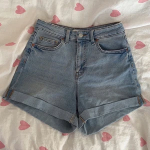Högmidjade jeansshorts - Ett par ljusblå jeansshorts från H&M i strl 36 med hög midja. Stängs med knapp och dragkedja!💞