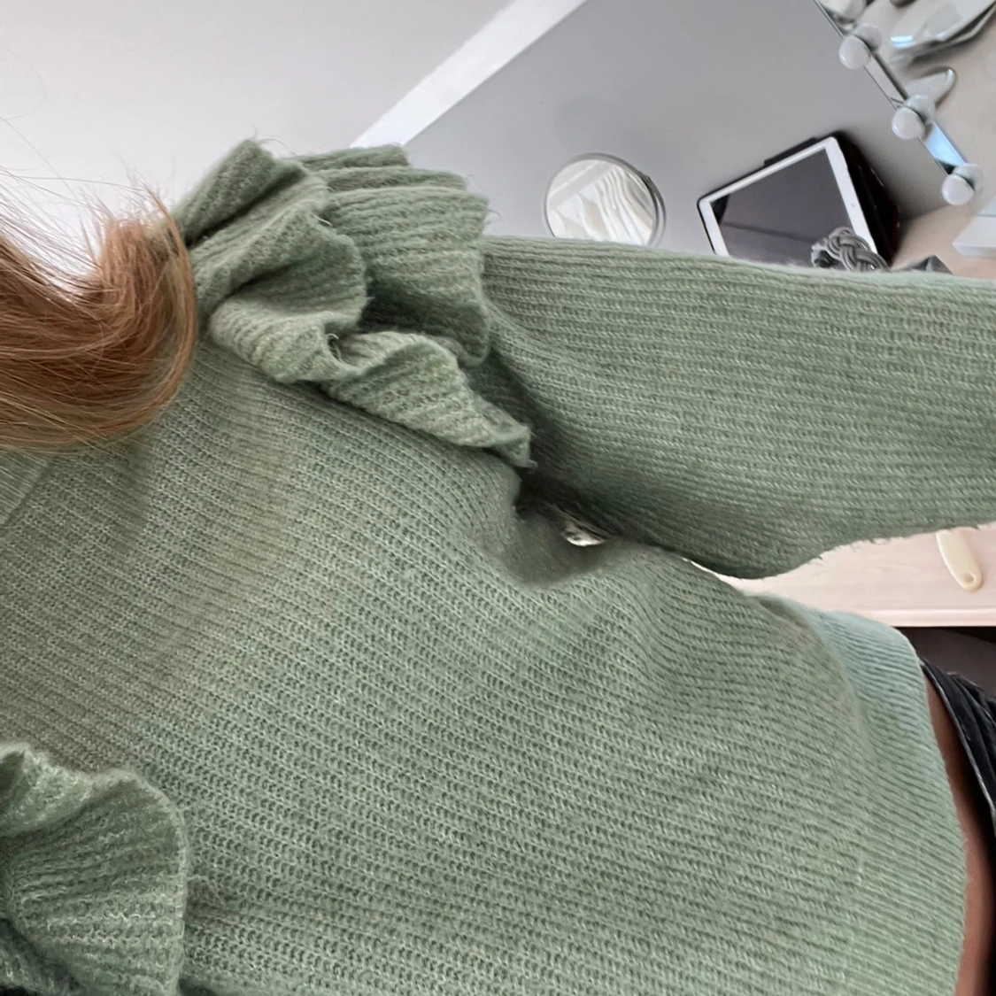 Grön stickad tröja med volanger