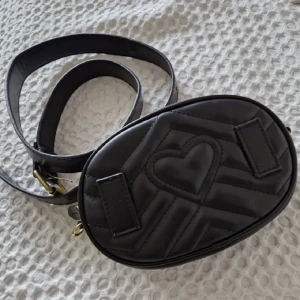 Svart magväska  - Svart magväska med ett hjärta. Onesize.