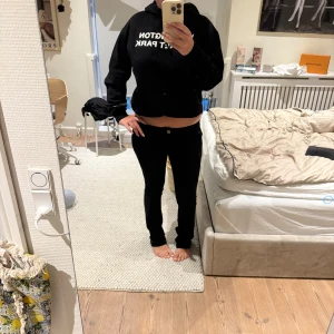 Svarta bootcut jeansbyxor - Säljer ett par svarta jeansbyxor med bootcut-snitt. Byxorna har låg midja och klassisk femficksdesign. Snygg passform som sitter tajt upptill och släpper ut vid anklarna. Perfekta till sneakers eller boots.