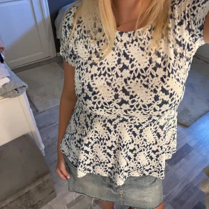 Vit och blå volang blus - Supersöt volangblus i vit och marinblått. Toppen har korta ärmar, rund halsringning och ett blommigt mönster. Köpt Second hand💗💗