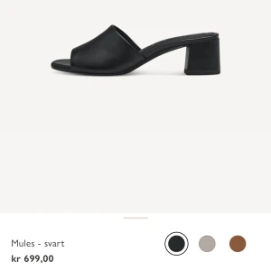 Svarta mules med klack från Tamaris - Svarta mules från Tamaris i läder i storlek 38. Skorna har en stabil låg klack och öppen tå. Aldrig använda. Org pris 699.