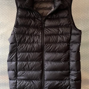 Svart dunväst med dragkedja - Snygg svart dunväst från uniqlo. Original pris: 600kr men jag säljer den för 200. Använd runt 5 gånger så den är i riktigt bra skick. Perfekt nu när det börjar bli kallare. Skriv om du har några frågor.