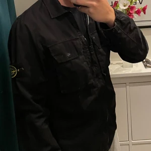 Svart jacka från Stone Island - Svart jacka från Stone Island. Jackan är i mycket bra skick och har inga skador eller liknande. Den är använd ett fåtal gånger. Priset kan diskuteras. Skriv vid frågor