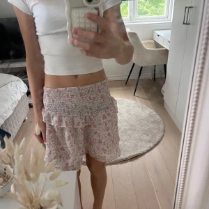 Blommig volangkjol från Gina Tricot - Supersöt kort kjol från Gina Tricot med blommigt mönster i rosa och grönt på vit botten 💕