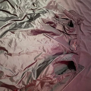 Svart quiltad dunjacka Explorer S - Svart värmeväst från Explorer i storlek S. Västen är quiltad med diskreta sömmar och har en glansig finish. Tillverkad i syntetmaterial och dun, perfekt för kyliga dagar. Snygg och enkel design med dragkedja och elastiska muddar.