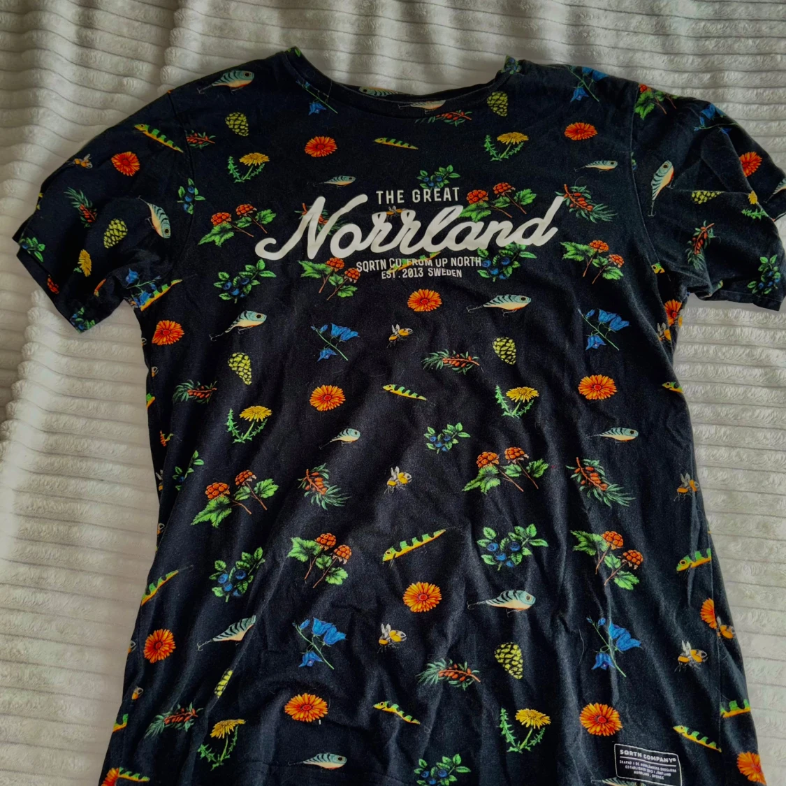 Svart t-shirt med blommigt och fiskmönster från Sqrtn Company