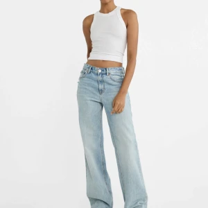 Ljusblå raka jeans från Stradivarius - Säljer ett par ljusblå jeans från Stradivarius med raka ben och hög midja. Jeansen har slitna detaljer vid fickorna och låret för en trendig look. Perfekta till en enkel topp eller hoodie.