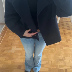Svart kappa med knappar - Säljer en marinblå kappa från ginatricot med stora knappar framtill, och den slutar vid höften.