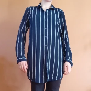 Mörkblå randig skjorta från HM - Lång, mörkblå skjorta från H&M med vita vertikala ränder. Har hängt i garderoben och näst intill oanvänd, dock lite lätt noprog på ett ställe vid insidan av kragen - se bild. Storlek S 💙