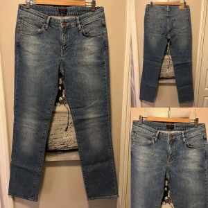 Blå jeansbyxor från Crocker - Säljer ett par klassiska blå jeans från Crocker i modellen 321. Byxorna har fem fickor, normal passform och raka ben. De är tillverkade i slitstarkt denim med snygga slitningar framtill och stängs med knapp och dragkedja. Knappt använda i jättefint skick.