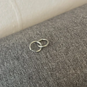 Silverfärgade örhängen i enkel design - Säljer ett par minimalistiska silverfärgade örhängen i rund form. Säljer en för 10kr och båda för 15kr!💘