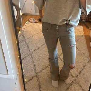Gråa jeans med hål i från Gina Tricot - Gråa jeans med egna hål i, säljer pågrund av att dom inte kommer till användning❣️