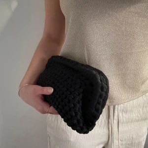 Svart handvirkad clutch / väska  - Säljer en svart handvirkad clutch / handväska som jag har virkat! Väskan är i ett mjukt garn och är väldigt rymlig! Kan bäras i handen som en clutch eller bäras i handtaget.  Kan Även Göra Andra Färger / storlekar💕 skriv för mått, olika på vissa 💕